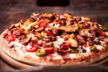 Gyros Pizza with jalapeno pepper, cherry tomatoes and mozzarella cheese. Soft focus. Close up.	