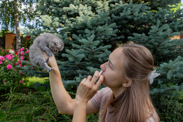 Woman Sneezing from Cat Allergy in Garden