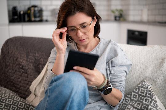 Woman At Home Reading An Interesting Modern E-Book