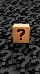 Wooden cube with question mark stands out from a pile of black question marks, symbolizing finding answers amidst uncertainty or problem-solving