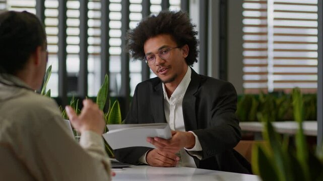 Two businessmen in business office African American leader insurance bank agent reading resume documents reject deny bad work result sad frustrated client man male worker holding head problem worried