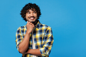 Young happy Indian man he wear yellow checkered shirt casual clothes put hand prop up on chin, lost...