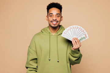 Young man of African American ethnicity wear green hoodie casual clothes hold in hand fan of cash...