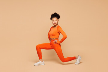Full body young fitness trainer instructor sporty woman sportsman wear orange clothes spend time in...