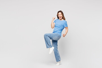 Full body overjoyed young woman wears blue t-shirt casual clothes do winner gesture clench fist...
