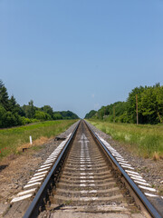 Fototapeta premium A train track in the middle of a grassy field