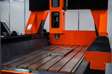 Large orange CNC machine for precision manufacturing and industrial milling. Shows modern...