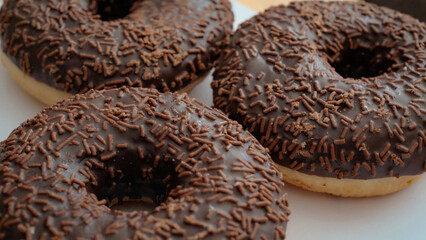Close-up of delicious chocolate donuts covered with a rich glaze and chocolate sprinkles