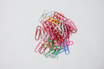 Pile of colorful paper clips on a white surface
