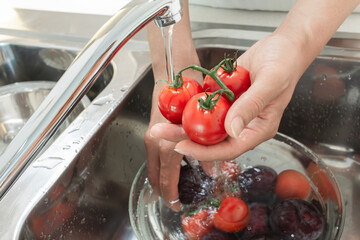 싱크대에서 세척하고 있는 신선한 과일