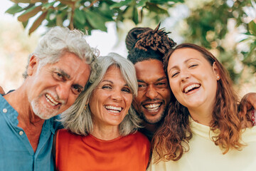 Happy multi-ethnic family laughing and embracing outdoors