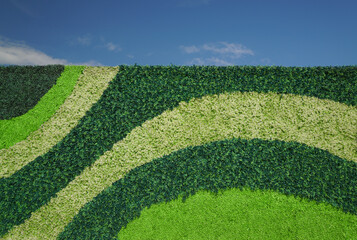 Plastic Plants Green Pattern on a Vertical Canvas with Bright Blue Sky. 