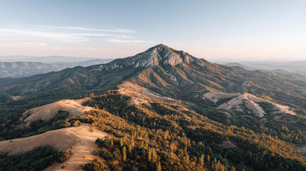 aerial view of stunning mountain range at sunset highlighting solitary peak