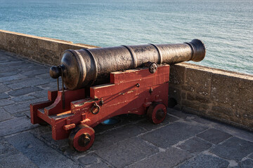 Historic cannon on the fortress walls of Saint-Malo facing the Atlantic Ocean at sunset