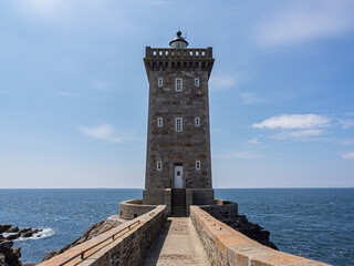 Front view of Kermorvan Lighthouse in Finistère, Brittany, with surrounding seascape and blue sky