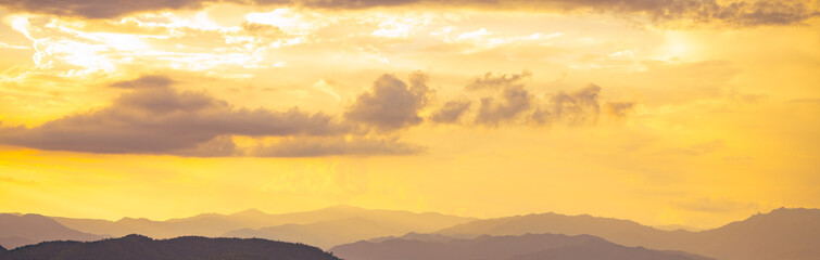 Golden sunrise over mountain range during early morning creating natural landscape background with warm light perfect for travel tourism marketing and outdoor adventure campaign materials