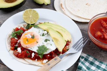 Huevos Rancheros on wooden table. Traditional Mexican breakfast