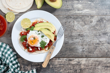 Huevos Rancheros on wooden table. Top view. Copy space. Traditional Mexican breakfast