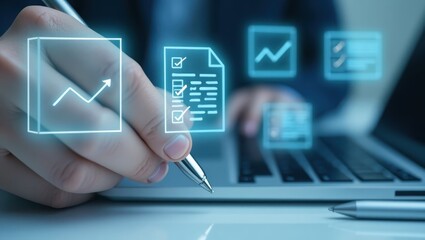 Hand holding pen over glowing icons on laptop.