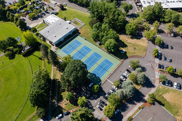 High resolution aerial drone picture of outdoor tennis courts and green fields near a high school in Cedar Mill, Portland, Oregon, captured on a clear summer day	
