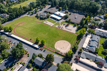 Aerial drone picture of a beautiful residential apartment complex in Cedar Mill, Portland, OR, captured at morning. Footage shows green courtyards, swimming pool, parking lots and housing buildings	
