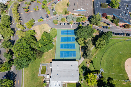 High resolution aerial drone picture of outdoor tennis courts and green fields near a high school in Cedar Mill, Portland, Oregon, captured on a clear summer day	
