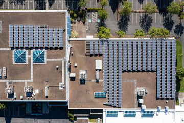 Aerial drone picture of a modern commercial building in Cedar Mill, Portland, OR, showcasing rooftop solar panels, HVAC units and large empty parking lot, promoting clean energy and sustainability	
