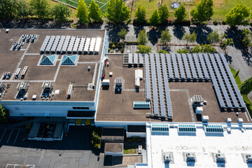 Aerial drone picture of a modern commercial building in Cedar Mill, Portland, OR, showcasing rooftop solar panels, HVAC units and large empty parking lot, promoting clean energy and sustainability	
