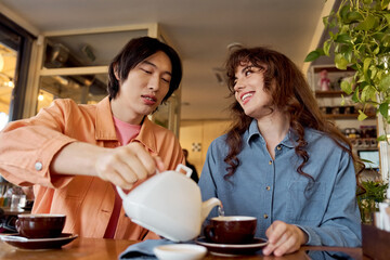 Multicultural friends share blissful moments at a cozy cafe while enjoying tea together