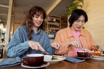 Friends sharing a joyful meal in a cozy multicultural cafe setting