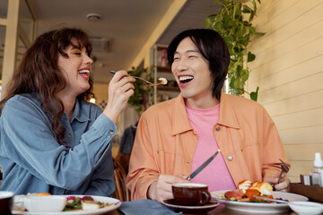 Multicultural friends sharing joy and laughter over brunch in a cozy cafe setting