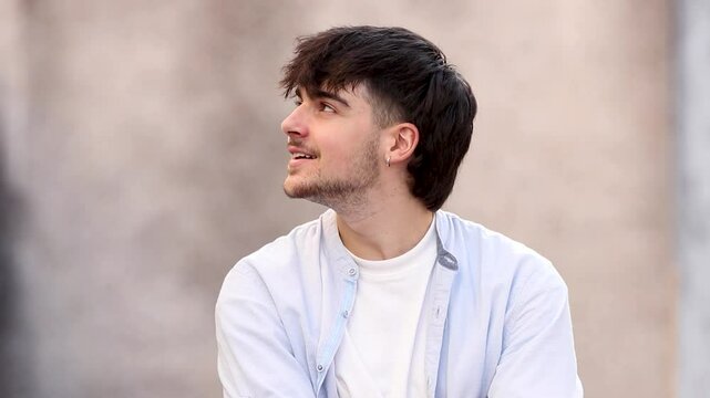 portrait of a young man looking to the side and at the camera outdoors