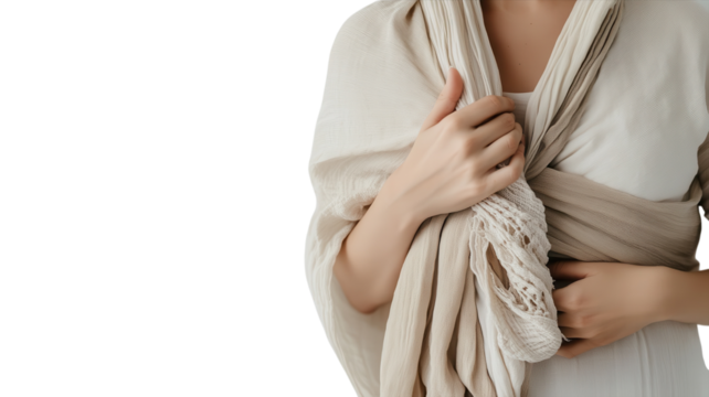 A person shows a babywearing technique with a soft wrap in a cozy indoor setting