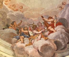 PIACENZA, ITALY - MAY 19, 2025: The baroque fresco of angels with the music instruments in cupola of the church Basilica di Santa Maria di Campagna by Bernardino Gatti from year 1543 