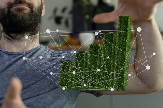 A man interacts with a holographic green growth chart, illustrating data network and sustainable growth.