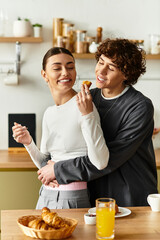 Loving couple shares a joyful moment in the kitchen over breakfast pastries and drinks