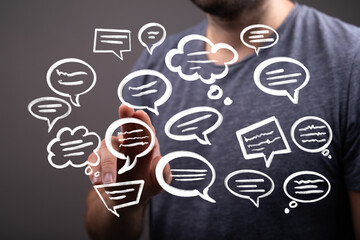 Image of a man interacting with digital speech bubbles, illustrating communication, networking, or...