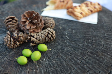 Pinecones and green olives on rustic wooden surface during autumn gathering