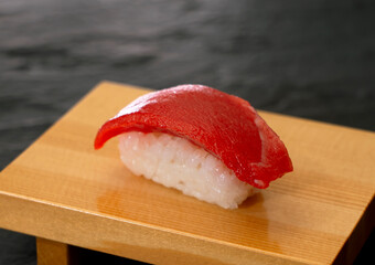 Maguro sushi, lean tuna sushi on sushi geta. マグロ（赤身）の寿司、寿司下駄