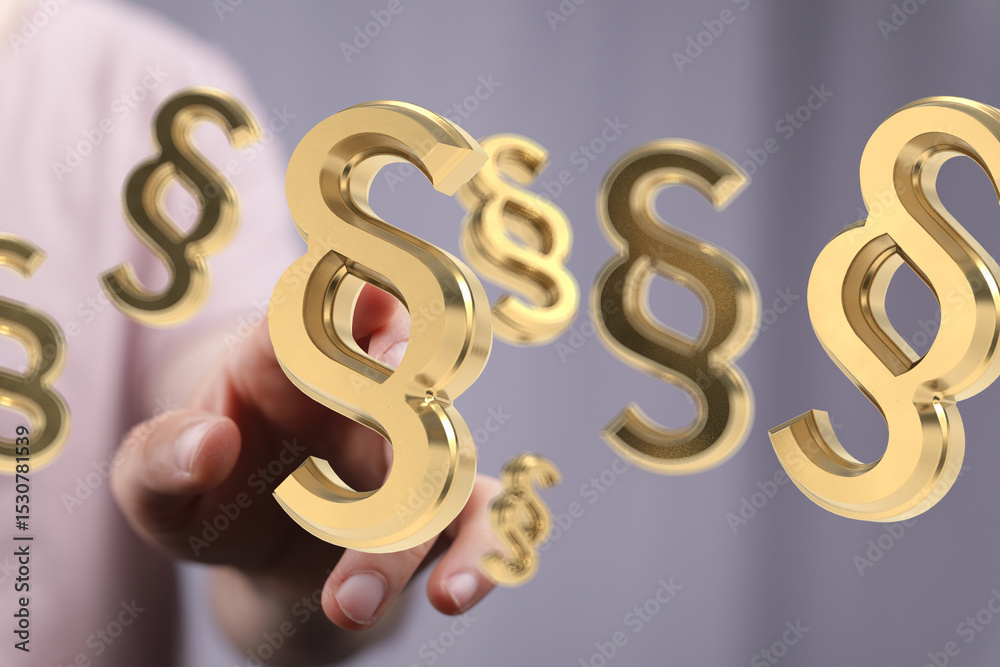 Poster Abstract image of golden paragraph symbols floating above a hand, representing legal concepts.