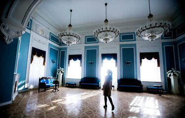 Elegant interior of a grand room with chandeliers and natural light in a historical building
