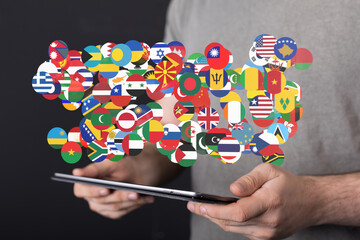 Person holding tablet displaying diverse world flags, symbolizing international communication and...