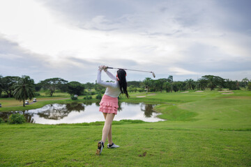 asian women swing and hitting golf ball at the golf course,