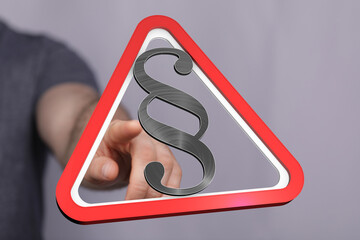 High-quality stock photo of a hand pointing at a legal warning sign with a paragraph symbol. Ideal...
