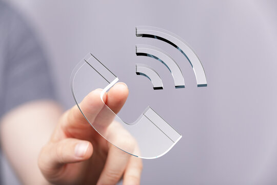 Hand interacting with a transparent phone icon and wifi signal. Modern communication technology.