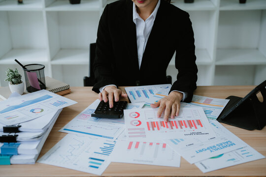 Close up businessman hand using calculator to budgeting and tax calculation monthly expenses. budget management and accounting on table. Business finance accounting banking concept.
