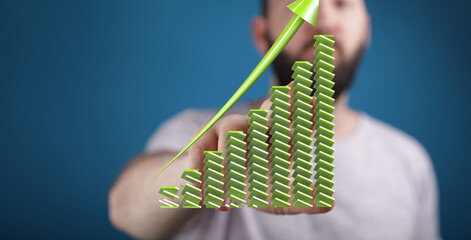 Stock photo of a man showcasing an upward trending green bar graph, symbolizing growth and success...