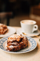 Almond croissant and cappuccino on the table