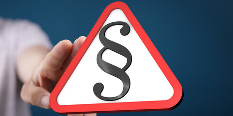 Hand holding a red triangle warning sign with a paragraph symbol.  Legal, law, warning concept.