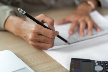 Architect drafting plans with pencil on workspace